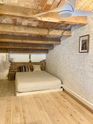 a bedroom with a bed and a brick wall at New penthouse duplex by the sea in Masnou