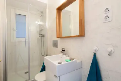 a white bathroom with a sink and a shower at Flateli Rossello 134 in Barcelona