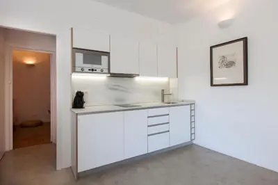 a kitchen with white cabinets and a counter top at Flateli Rossello 134 in Barcelona