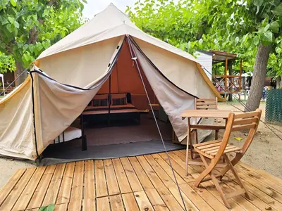 a tent with a bed and a rug in it at Camping Costa Dorada in Canet de Mar