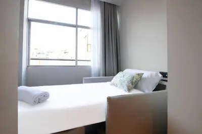 a room with a white bed and a window at Sagrada família essence in Barcelona