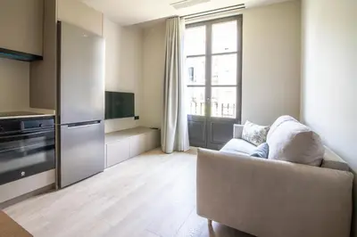a living room with a couch and a kitchen at Sagrada família essence in Barcelona