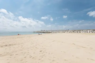 a beach with people laying on the sand at Matarolux 2 in Mataró
