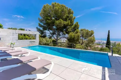 a bedroom with a bed and a dresser at Cool & Modern Villa Giovanna with Air Conditioning, Private Pool & Sea Views in Sitges