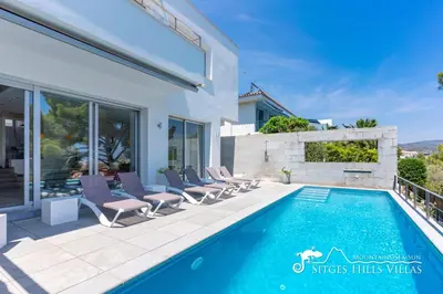 a kitchen with white cabinets and black counter tops at Cool & Modern Villa Giovanna with Air Conditioning, Private Pool & Sea Views in Sitges