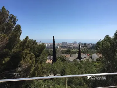 a view of a city from a hill with trees at Cool & Modern Villa Giovanna with Air Conditioning, Private Pool & Sea Views in Sitges