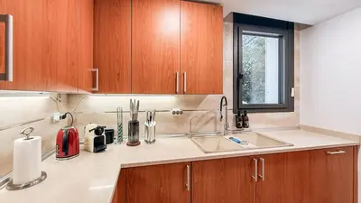a kitchen with a sink and wooden cabinets at Villa Marina in Sitges