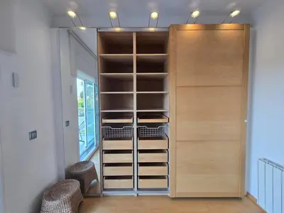 a walk in closet with wooden doors and shelves at Aquamarina Apt | Seaviews | 1' beach | Family in San Pol de Mar