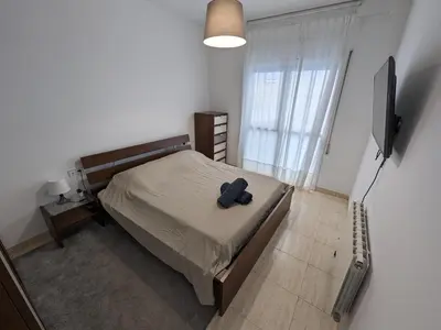 a bedroom with a bed and a flat screen tv at Large and calm 3 bedroom apartment with terrace in Barcelona