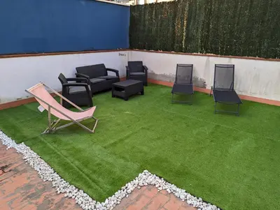 a group of chairs and chairs on a green lawn at Large and calm 3 bedroom apartment with terrace in Barcelona