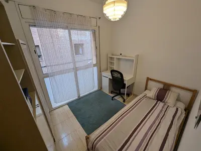 a bedroom with a bed and a desk and a window at Large and calm 3 bedroom apartment with terrace in Barcelona