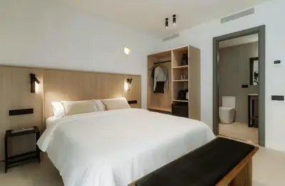 a bedroom with a large white bed and a bathroom at Lixar's apartment in Hospitalet de Llobregat