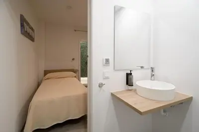 a bathroom with a sink and a bed at Hotel Plini in Hospitalet de Llobregat