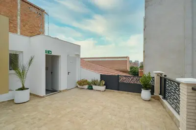an apartment patio with potted plants and a balcony at Hotel Plini in Hospitalet de Llobregat