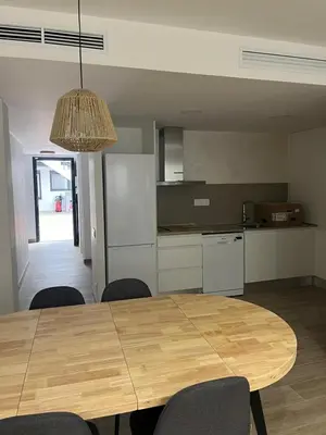 a dining room table with chairs and a kitchen at Tr3sor B2 in Calella