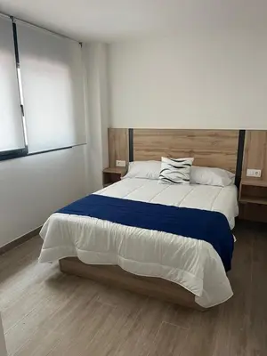 a bedroom with a large bed with a blue blanket at Tr3sor B2 in Calella