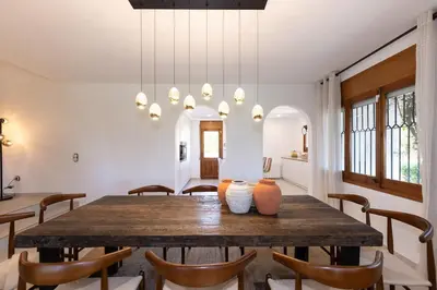 a dining room with a wooden table and chairs at Villa Carmen - Peaceful Eco-Luxury with private pool in Cunit