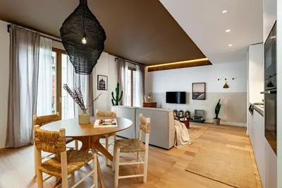 a living room with a couch and a kitchen at Tenere - 1 bedroom and pool in Gràcia in Barcelona