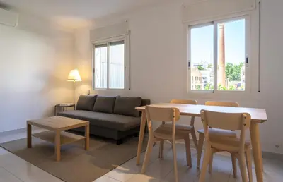 a living room with a couch and a table and chairs at Winahost Barcelona Sants in Barcelona
