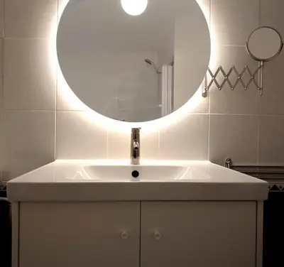 a bathroom with a sink with a round mirror at Winahost Barcelona Sants in Barcelona