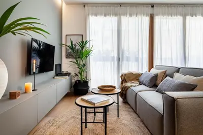 a dining room with a table and chairs and a painting at Oetune - 2 bedrooms and office in Gràcia in Barcelona