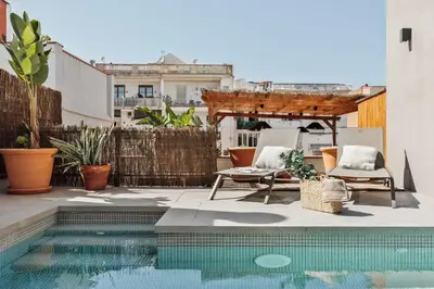 a swimming pool with chairs and a building at Sanur - 2 bedrooms in Gràcia in Barcelona