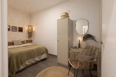 a bedroom with a bed and a mirror and stool at Damar - 2 bedrooms and balcony in Eixample Dreta in Barcelona