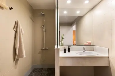a wicker chair sitting next to a table with a mirror at Damar - 2 bedrooms and balcony in Eixample Dreta in Barcelona