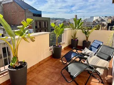 a balcony with chairs and plants on a roof at Attic with terrace Barcelona center in Barcelona