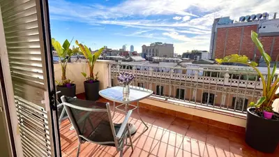 a balcony with a table and a view of a city at Attic with terrace Barcelona center in Barcelona