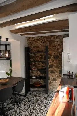 a kitchen with a table and a stone wall at Barcelona Badalona Relax PLAYA y METRO in Badalona