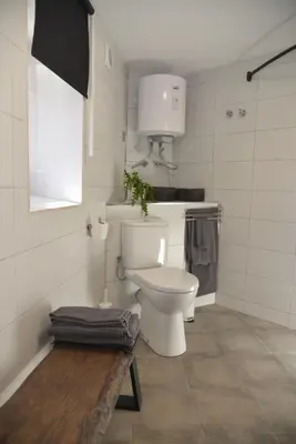 a white bathroom with a toilet and a window at Barcelona Badalona Relax PLAYA y METRO in Badalona