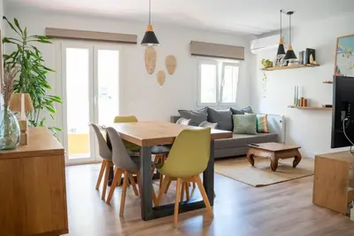 a kitchen and living room with a wooden table and chairs at Apartamento - Recinto Modernista in Barcelona