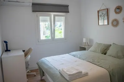 a white bedroom with a bed and a window at Apartamento - Recinto Modernista in Barcelona