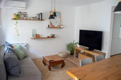a living room with a couch and a tv at Apartamento - Recinto Modernista in Barcelona