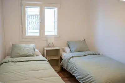 a bedroom with two beds and a window at Apartamento - Recinto Modernista in Barcelona