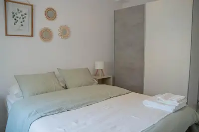 a white bed in a room with a white wall at Apartamento - Recinto Modernista in Barcelona