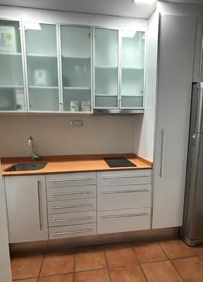 a kitchen with white cabinets and a sink at Balcón, WiFi y aire acondicionado en Plaza Cataluña in Barcelona