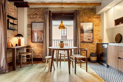 a dining room with a table and chairs and a brick wall at Shan - 1 bedroom and balcony in El Born in Barcelona