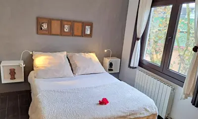 a bedroom with a bed with a red flower on it at Barcelona Badalona tu refugio playa y metro in Badalona