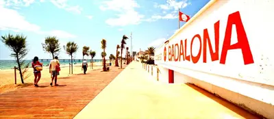 a group of people walking on a boardwalk next to the beach at Barcelona Badalona tu refugio playa y metro in Badalona