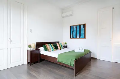 a bedroom with a bed with a green blanket at Apartamento Premium 5 Hab con Balcón a Gran Vía - Grupos hasta 10 - Passeig Gràcia 7min in Barcelona