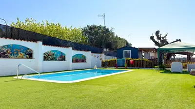 a backyard with a white fence and a yard with a pool at Camping Costa Dorada Tienda Lua in Canet de Mar