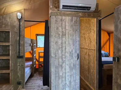 a kitchen with a stainless steel refrigerator and a window at Camping Costa Dorada Tienda Lua in Canet de Mar