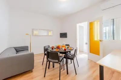 a dining room and living room with a table and chairs at Key Barcelona Sagrada Familia House Terrace in Barcelona
