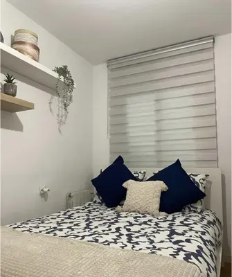 a bedroom with a bed with blue and white pillows at Alojamiento espacioso ideal para visitas en grupo in Terrassa