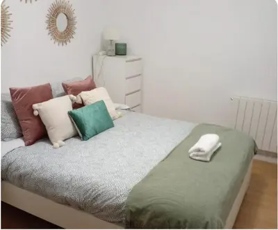 a bedroom with a bed with pillows and a mirror at Alojamiento espacioso ideal para visitas en grupo in Terrassa