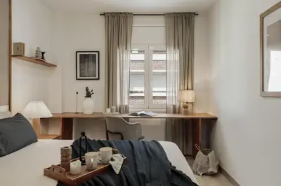 a bedroom with a bed and a kitchen at Briso - 3 bedrooms and balcony in Vila de Gràcia in Barcelona