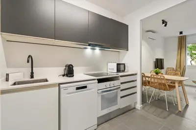 a kitchen with white appliances and a table with chairs at Flateli Espronceda 01 in Barcelona