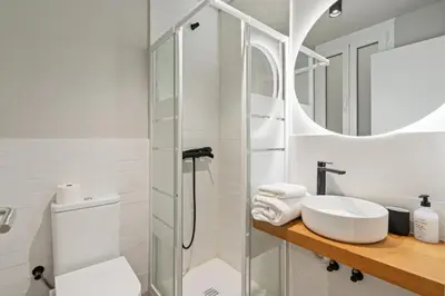 a white bathroom with a sink and a shower at Flateli Espronceda 01 in Barcelona